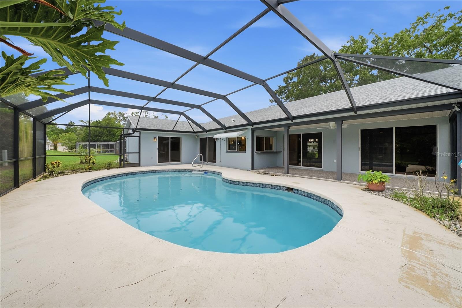 Inviting screened pool with a generous deck and multiple sliding doors connecting the home to the outdoor living area.