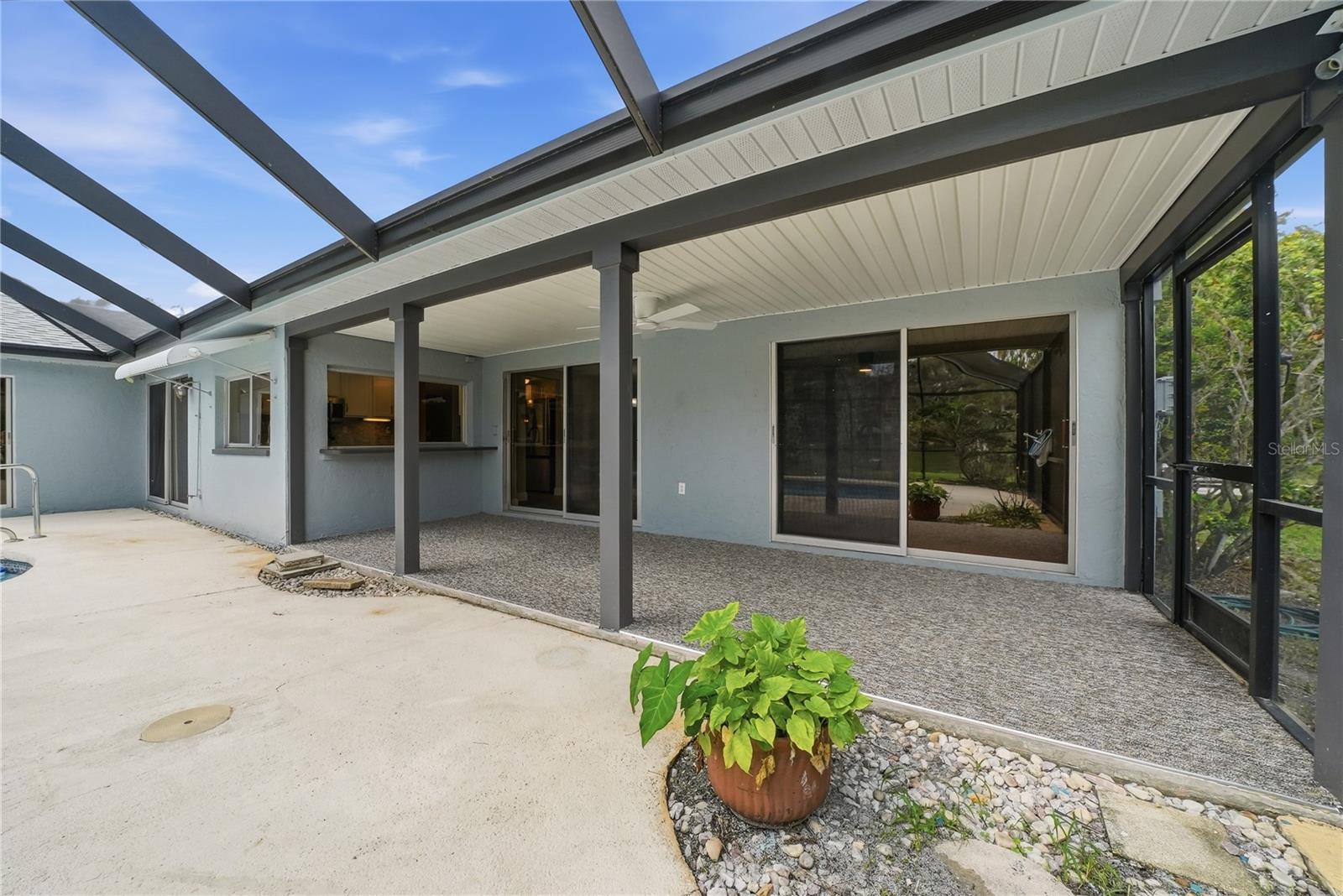 Covered lanai with ceiling fan, pass-through window, and convenient access from multiple interior living areas.