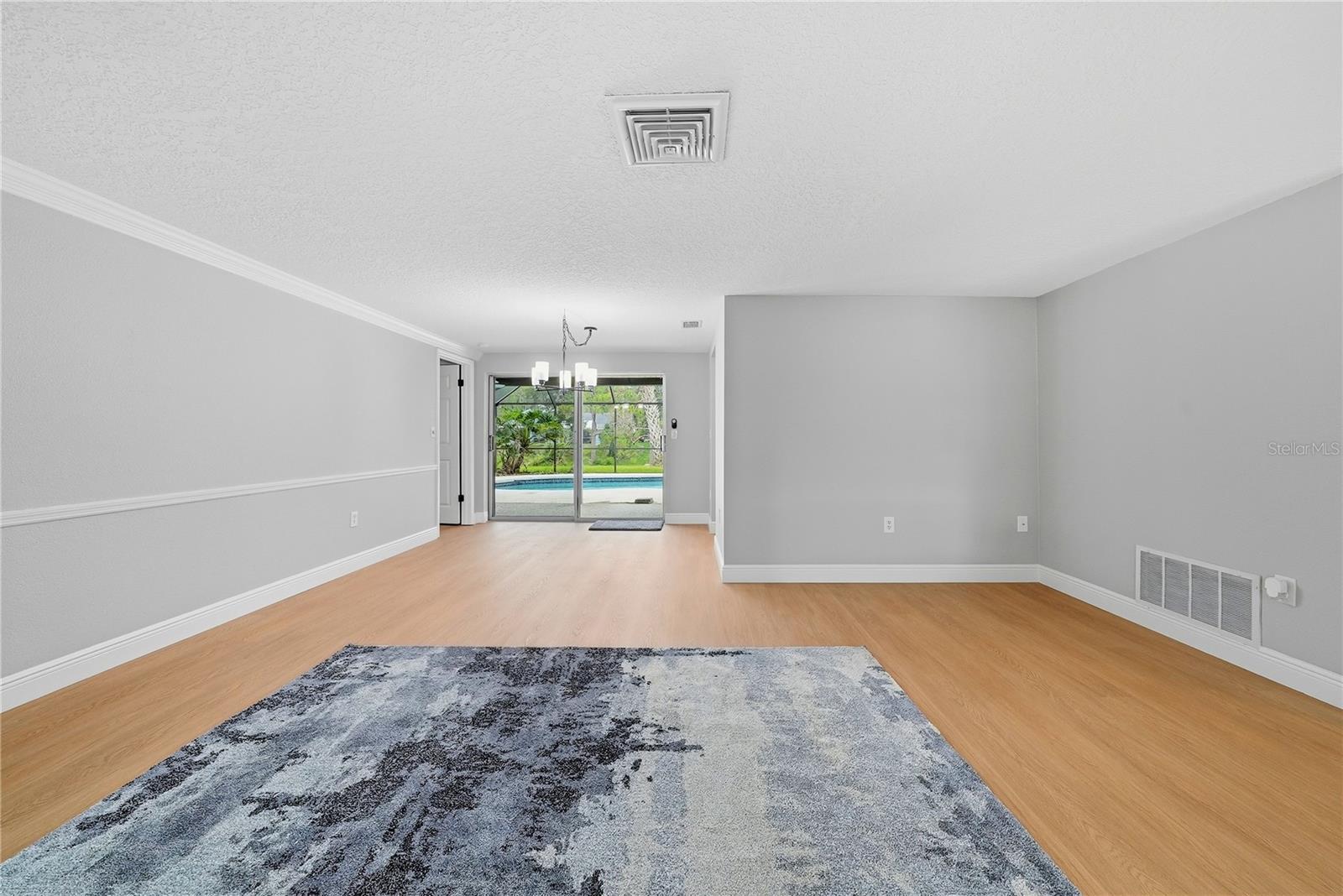 Spacious family room with an open flow to the dining area and direct views of the screened pool.