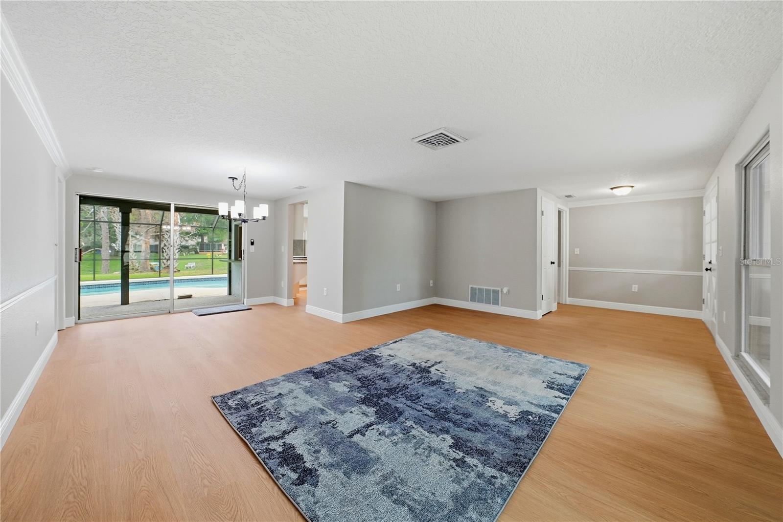 Bright and open gathering space with multiple living and dining configurations and easy access to the pool area.