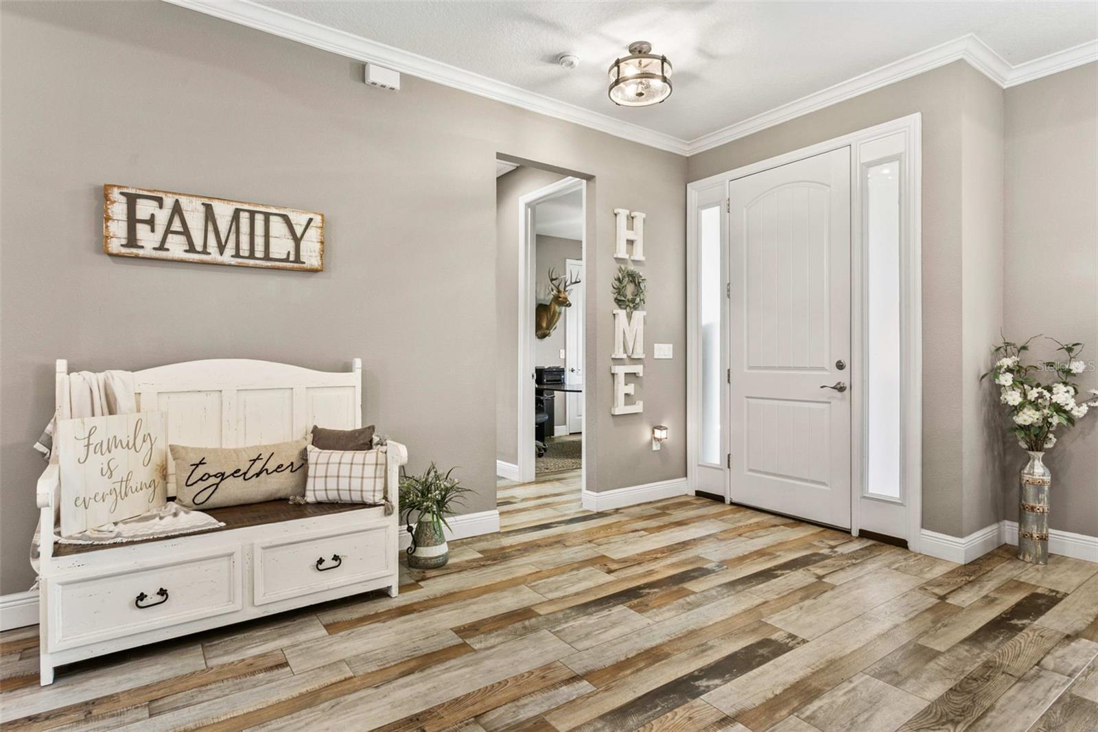 Elegant foyer with a custom wood entry door and designer finishes creating a warm welcome.