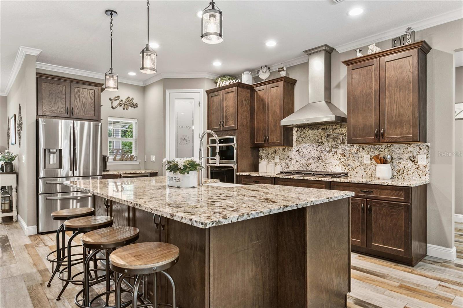 Chef's kitchen featuring custom cabinetry, granite countertops, premium appliances, and a large center island.