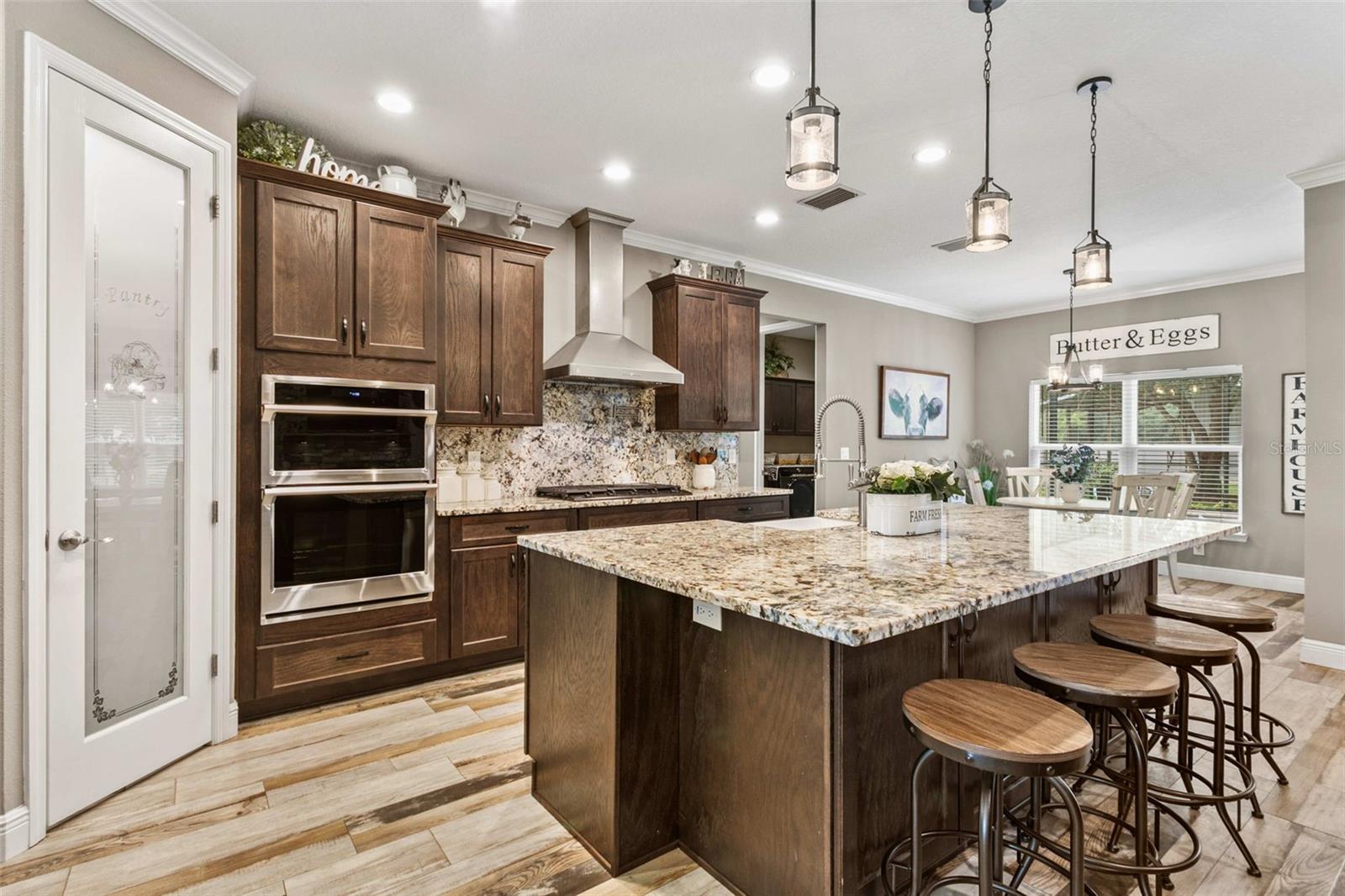 Chef's kitchen featuring custom cabinetry, granite countertops, premium appliances, and a large center island.