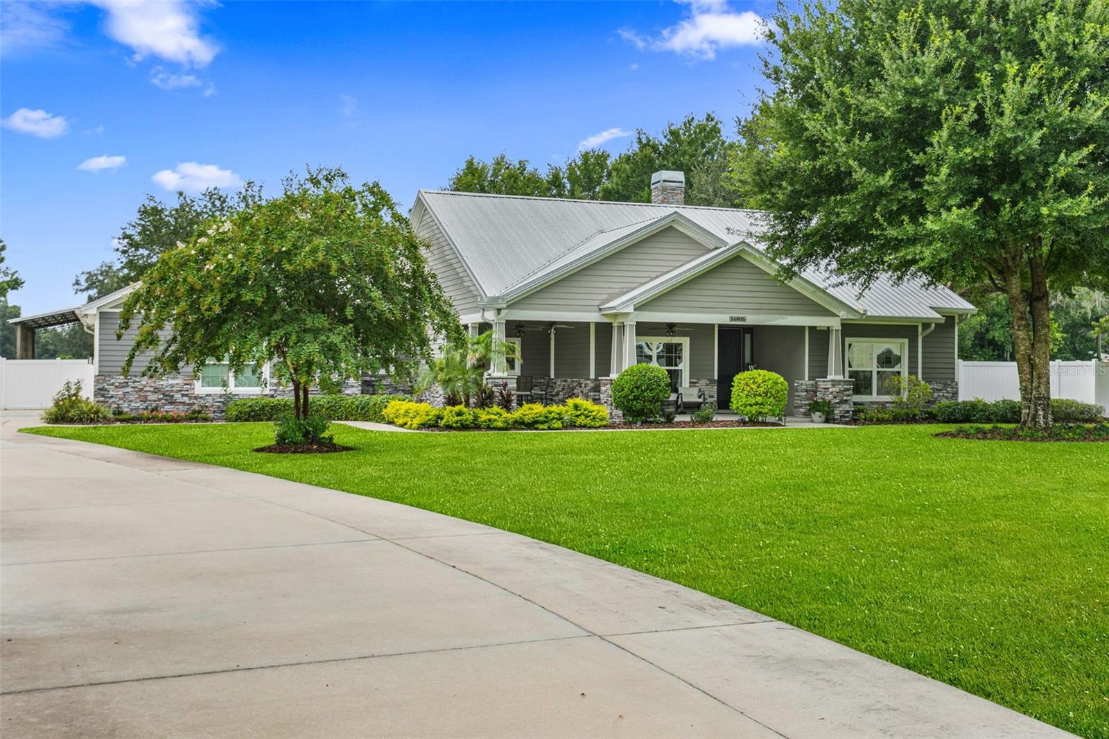 Beautifully landscaped one-acre homesite featuring a sweeping driveway, mature shade trees, and exceptional curb appeal surrounding this custom-built estate.