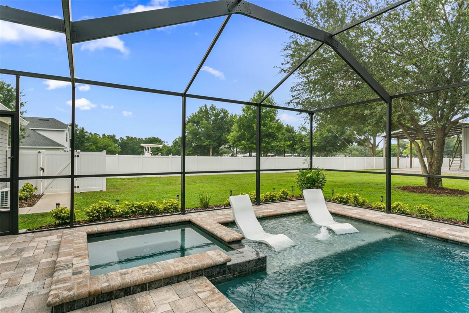 Sparkling screened pool with tranquil water views and expansive outdoor living.